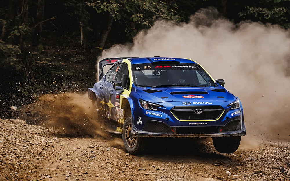 Blue and yellow number 21 Subaru WRX throwing gravel at Overmountain Rally Tennessee in 2026.