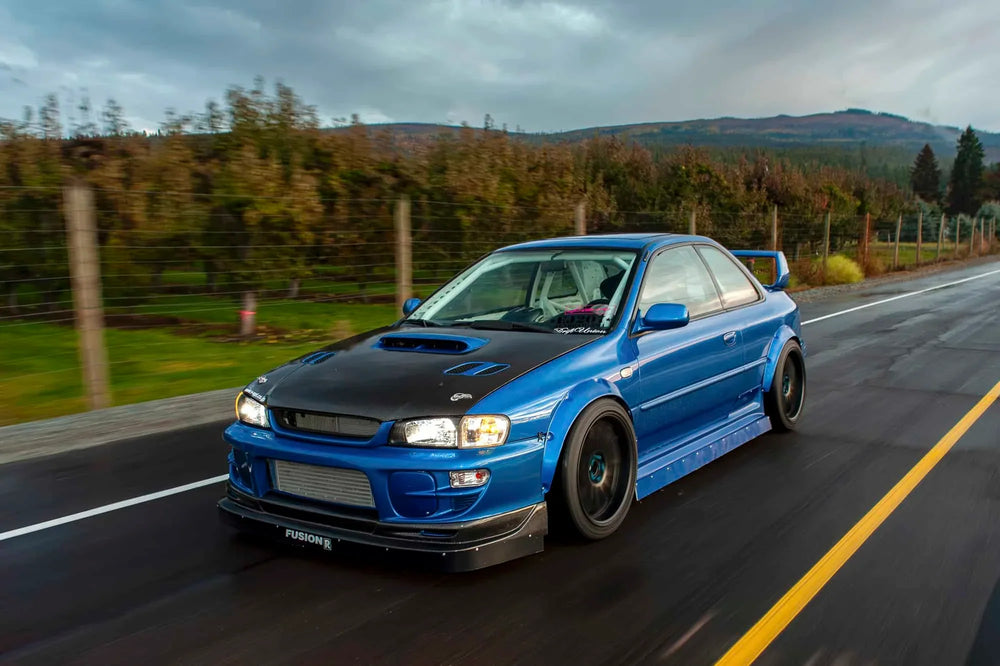 Dave Mann blue 1998 Subaru Impreza 2.5RS driving on a rural road.