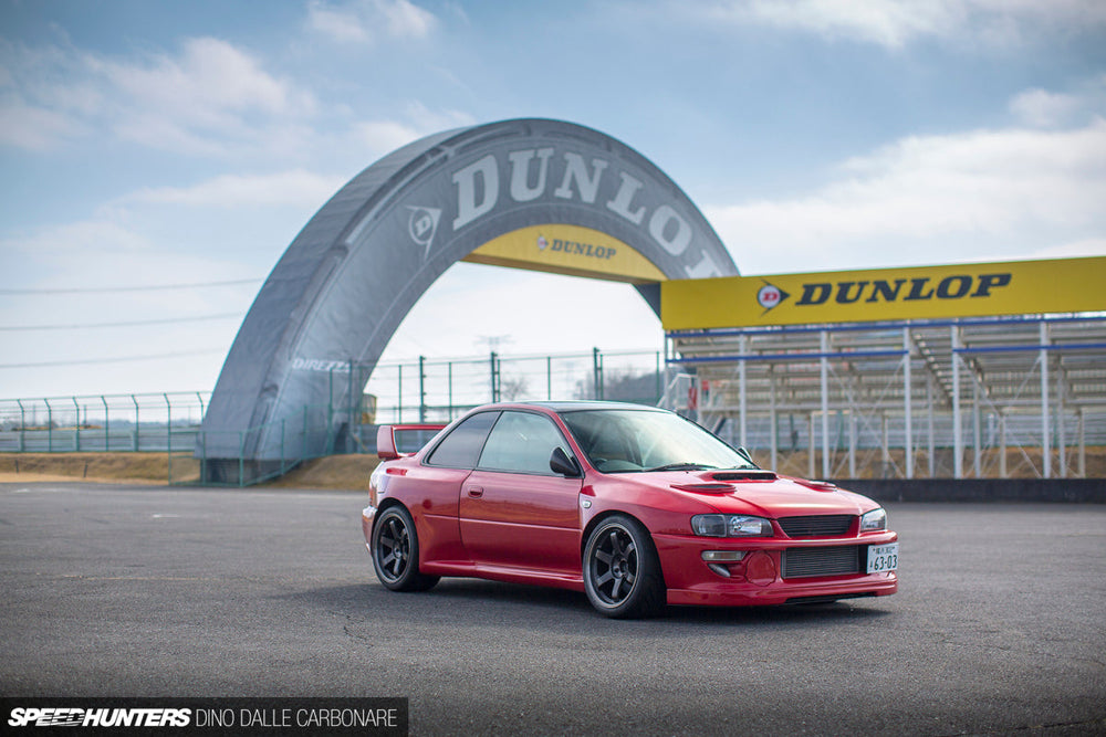 Red Subaru Impreza coupe at a circuit