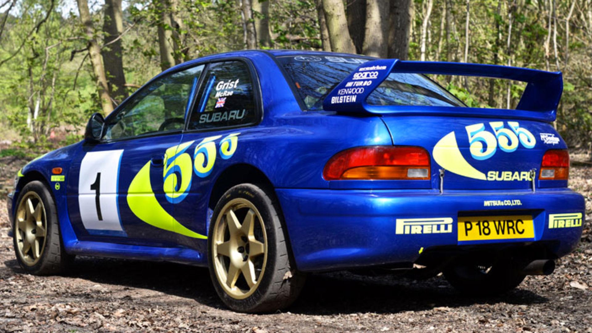 Blue and yellow rally-liveried Impreza viewed from behind